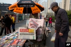 A man looks at a newsstand with a copy of the day's Global Times displayed on a basket in Beijing, April 5, 2016. The nationalistic tabloid published an editorial saying an unidentified "powerful force" was behind the documents leaked from a Panama-based law firm that name relatives of current and retired Chinese politicians, including President Xi Jinping, as owning offshore companies.