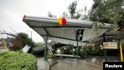 Oboreno stablo leži na srušenom krovu jednog restorana brze hrane u Vilmingtonu u Severnoj Karolini.