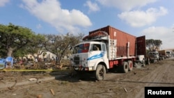 Trailers are parked outside a police cordon after a suicide car bomb went off at the entrance of Somalia's biggest port in its capital, Mogadishu, Dec. 11, 2016.