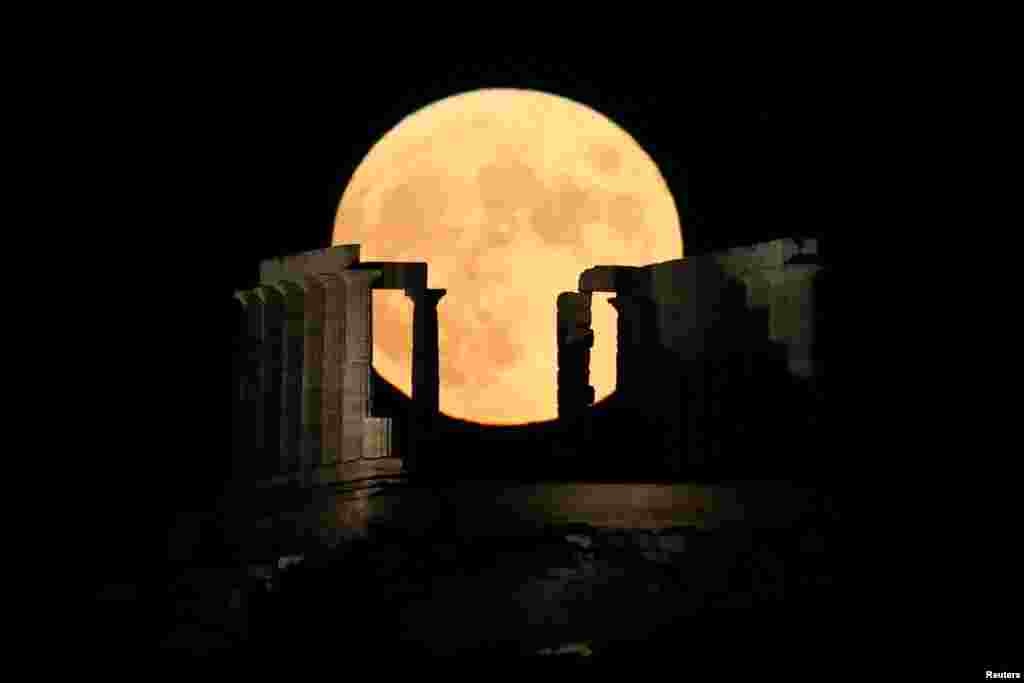 A full moon rises behind the Temple of Poseidon in Cape Sounion, near Athens, Greece, Aug. 3, 2020.
