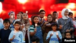 Family members hold candles during the fifth annual remembrance event for the missing Malaysia Airlines flight MH370, in Kuala Lumpur, Malaysia March 3, 2019. (REUTERS/Lai Seng Sin)