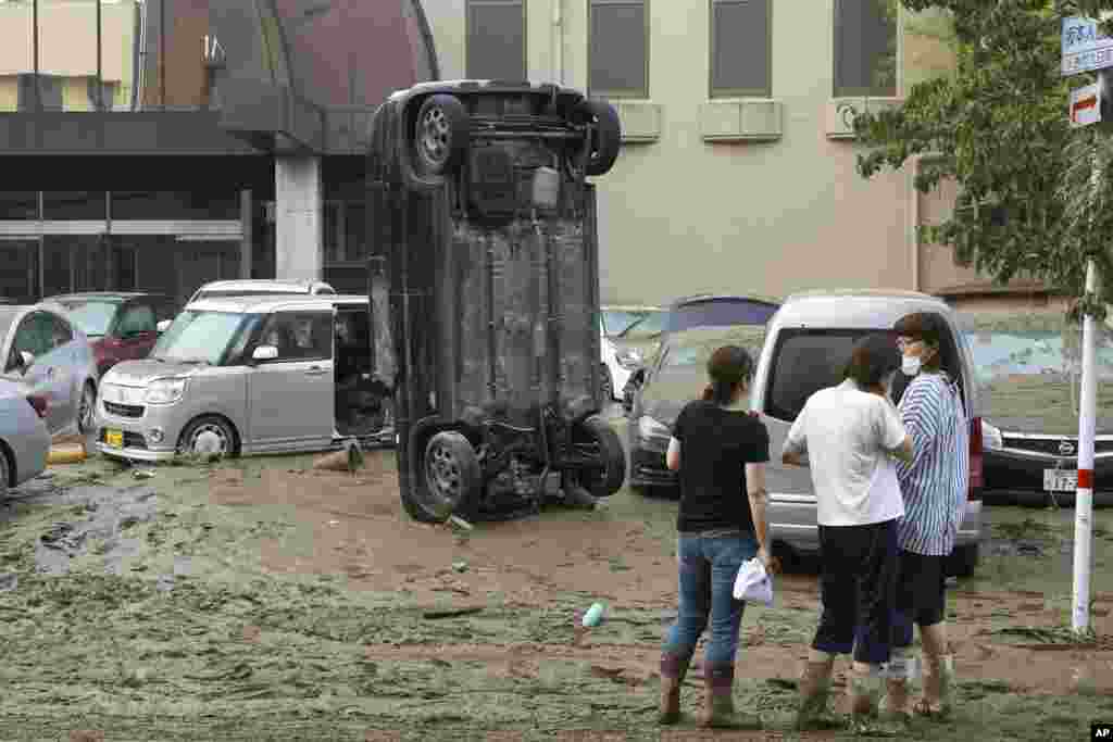 A car stands vertically on a muddy road after being washed away by flood, in Hitoyoshi, Kumamoto prefecture, southwestern Japan.