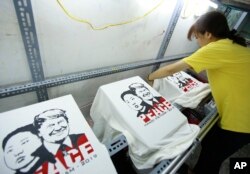 2차 미-북 정상회담이 열리는 베트남 하노이에서 21일 티셔츠 가게 직원이 도널드 트럼프 미국 대통령과 김정은 북한 국무위원장의 얼굴을 인쇄한 티셔츠를 준비하고 있다.