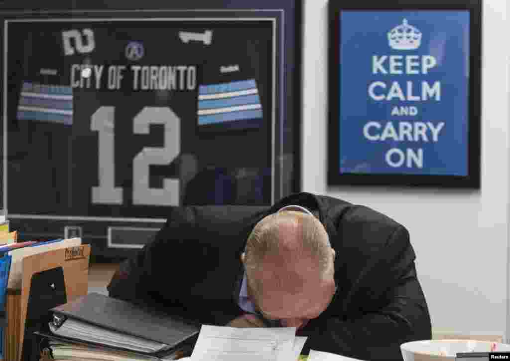 Toronto Mayor Rob Ford laughs in front of a &quot;Keep Calm and Carry On&quot; sign at City Hall in Toronto, Canada, Mar. 19, 2014. Ford, who made global headlines last year after admitting he had smoked crack cocaine, was caught up in fresh controversy after a new video showed him agitated and apparently swearing outside city hall.