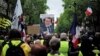Yellow vest protesters, one carrying a placard with a picture and a quote of French President Emmanuel Macron ("Let them come get me"), march in Paris, May 4, 2019.