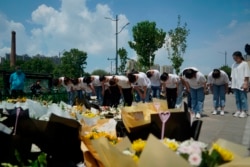 河南鄭州市民在地鐵5號線站台前給洪災死難者獻上鮮花，鞠躬致哀。（2021年7月27日）