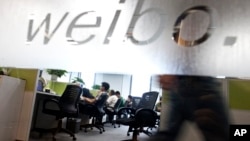 Employees work at their desks at a Sina Weibo office in Beijing's leading microblog site, (File photo).