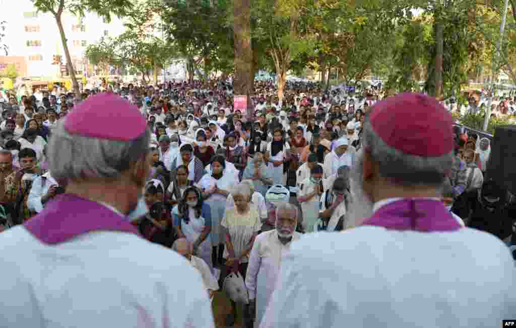 Warga Kristen India and orang-orang dari kelompok-kelompok minoritas mendengarkan sambutan Uskup Agung&nbsp;​Stanislaus Fernandes SJ dari Gandhinagar (kiri) dan Uskup Thomas Macwan dari Ahmedabad pada sebuah acara protes damai di Ahmedabad, sebagai reaksi atas pemerkosaan ramai-ramai terhadap seorang biarawati yang sudah lanjut usia.