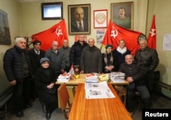 Jiuli Sikmashvili (C), 77, a leader of the United Communist Party of Georgia, poses among other activists before a portrait at the party office in Tbilisi, Georgia, Nov. 30, 2016.