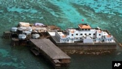 FILE - A Chinese flag flies from one of the two newly-finished concrete structures on the Mischief Reef off the disputed Spratlys group of islands in the South China Sea, Feb. 8, 1999. 