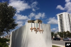 Six crosses are placed at a makeshift memorial on the Florida International University campus in Miami on Saturday, March 17, 2018, near the scene of a pedestrian bridge collapse that killed at least six people on March 15.