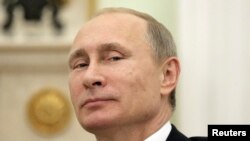 FILE - Russian President Vladimir Putin, shown in 2014, plans to address the U.N. General Assembly on Sept. 28, 2015. His country has ramped up its military presence in Syria. 