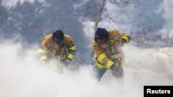 Westminster Fire Department members continue to put out flames from the Marshall Fire in Louisville, Colorado, U.S. December 31, 2021. REUTERS/Alyson McClaran