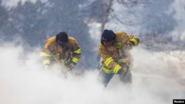 Westminster Fire Department members continue to put out flames from the Marshall Fire in Louisville, Colorado, U.S. December 31, 2021. REUTERS/Alyson McClaran