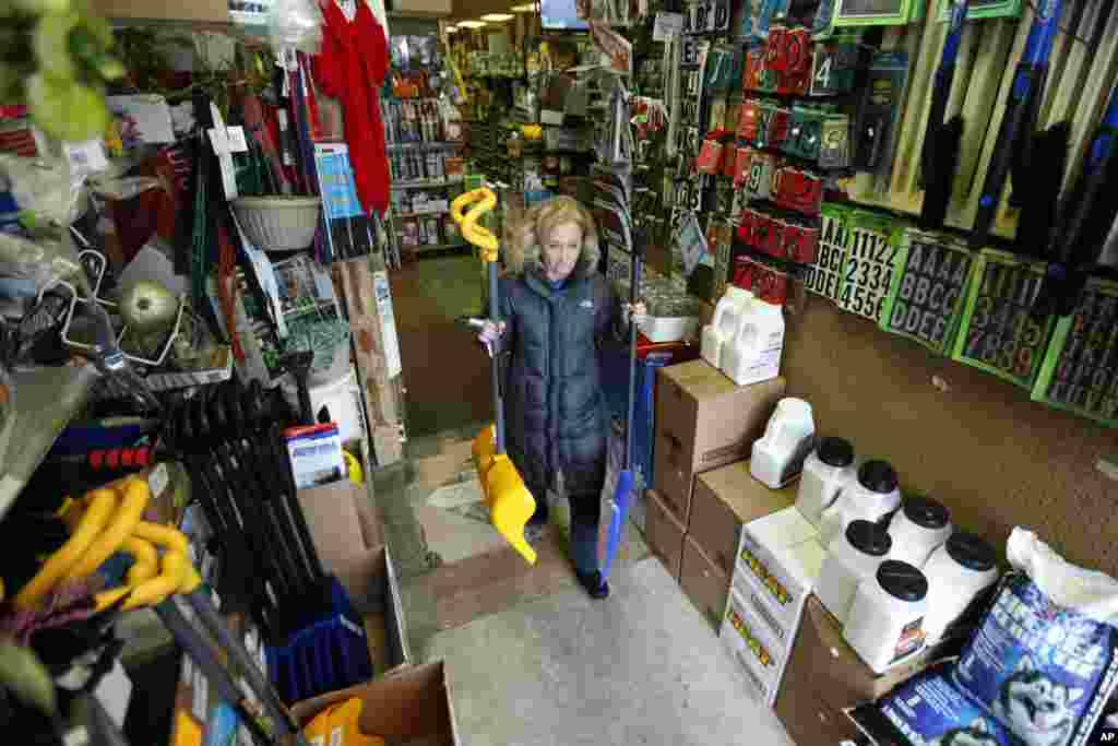 Donna Przychodzki, of Secaucus, N.J., leaves Meadowlands Hardware with two snow shovels purchased in preparation for the weekend's storm, Jan. 22, 2016, in Rutherford, New Jersey. 