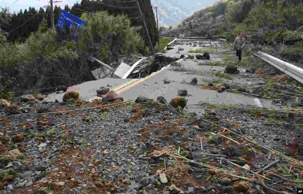 A man walks a damaged area by earthquakes in Minamiaso, Kumamoto prefecture, April 17, 2016.