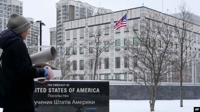 A woman walks past the U.S. Embassy in Kyiv, Ukraine, Monday, Jan. 24, 2022. (AP Photo/Efrem Lukatsky)