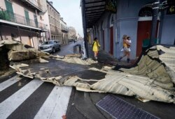 Bagian atap yang tertiup angin dari sebuah bangunan di French Quarter akibat hantaman Badai Ida, menghalangi persimpangan jalandi New Orleans, Louisiana, 30 Agustus 2021. (AP Photo/Eric Gay)