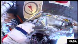 Russian cosmonauts perform a spacewalk, seeking to resolve the mystery of a small hole found in the side of a craft docked at the International Space Station, Dec. 11, 2018. (NASA TV)