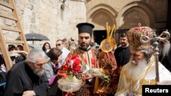 Greek Orthodox Patriarch of Jerusalem Metropolitan Theophilos (R) outside the Church of the Holy Sepulchre in Jerusalem's Old City, April 17, 2014.