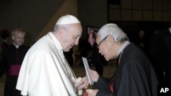 In this Jan. 10, 2018 photo made available the Vatican newspaper L'Osservatore Romano, retired archbishop of Hong Kong Cardinal Joseph Zen hands a letter to Pope Francis at the end of his weekly general audience.