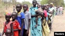 File - Residents displaced due to the fighting between government and rebel forces in the Upper Nile capital Malakal wait at a World Food Program outpost.