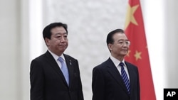 Japan's Prime Minister Yoshihiko Noda (L) and China's Premier Wen Jiabao listen to their national anthems during a welcome ceremony at the Great Hall of the People in Beijing, December 25, 2011