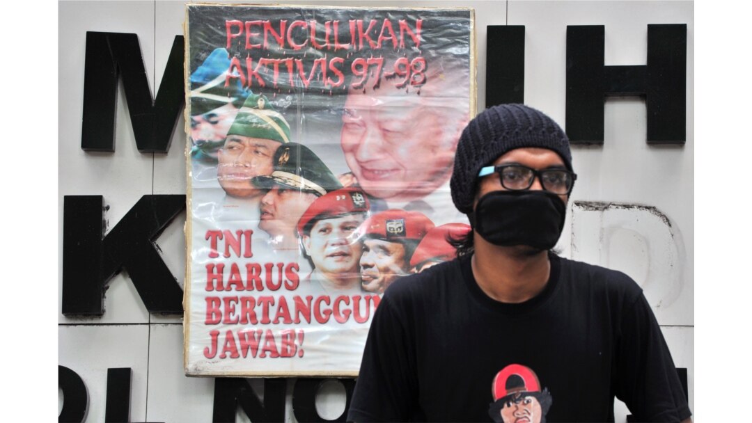 Seorang pengunjuk rasa duduk di samping spanduk yang bertuliskan "Penculikan Aktivis 1997-1998, TNI Harus Bertanggung Jawab" saat melakukan protes terhadap Prabowo Subianto di Jakarta, 20 Mei 2014. (Foto: dok).