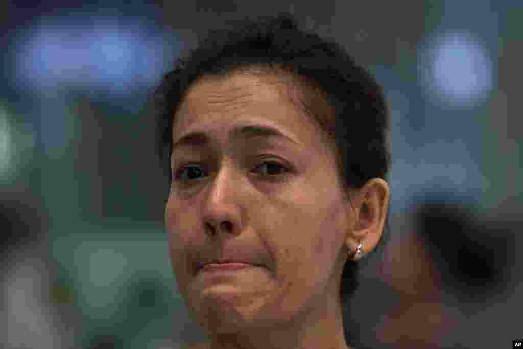 2014年9月15日，维吾尔族学者伊力哈木·土赫提的妻子古再丽努尔在飞往乌鲁木齐前和朋友们告别时眼含泪花。 