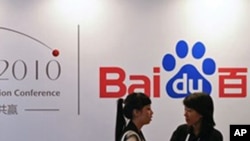 In this Sept. 2, 2010, file photo, a Baidu employee, right, chats with a visitor during the Baidu Technology Innovation Conference held in Beijing, China.