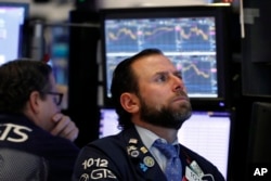 Specialist Michael Pistillo, right, works on the floor of the New York Stock Exchange, Jan. 3, 2019.