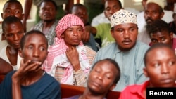 FILE - Men, part of the 70 arrested during a police raid on a mosque, sit in a court in Shanzu, Feb. 12, 2014. 