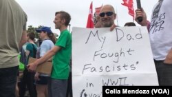 Un contra manifestante en Boston porta un cartel que dice: "Mi papá luchó contra el fascismo en la Segunda Guerra Mundial. Van a perder de nuevo".