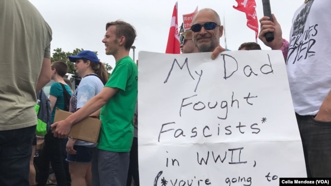 Un contra manifestante en Boston porta un cartel que dice: "Mi papá luchó contra el fascismo en la Segunda Guerra Mundial. Van a perder de nuevo".