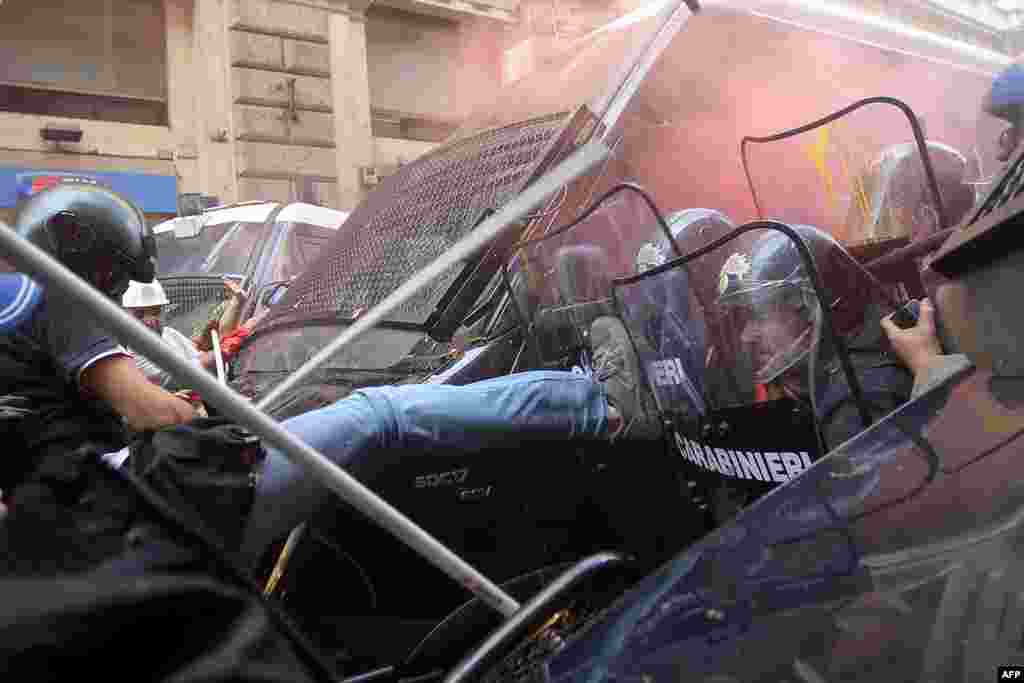Người biểu tình đụng độ với cảnh sát chống bạo loạn trong một cuộc biểu tình đòi nhà giá vừa túi tiền và phản đối các biện pháp thắt lưng buộc bụng của chính phủ trong trung tâm thành phố Rome.