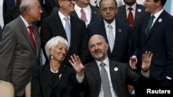 European Economic and Financial Affairs Commissioner Pierre Moscovici and International Monetary Fund Managing Director Christine Lagarde speak as they wait for a group photo of the G-20 finance ministers and central bank governors in Ankara, Turkey, Sept