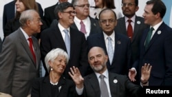 European Economic and Financial Affairs Commissioner Pierre Moscovici and International Monetary Fund Managing Director Christine Lagarde speak as they wait for a group photo of the G-20 finance ministers and central bank governors in Ankara, Turkey, Sept