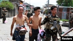 Tentara Pemerintah Filipina mendampingi warga yang disandera dan dijadikan 'tameng manusia' oleh para pemberontak muslim di kota Zamboanga, Filipina (17/9).