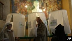 Граждане Грузии покидают избирательные кабинки, проголосовав на президентских выборах. Тбилиси. 27 октября 2013 г. 