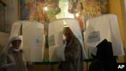 Georgians leave voting booths to cast their ballots during the presidential election in Tbilisi, Georgia, Oct. 27, 2013. 