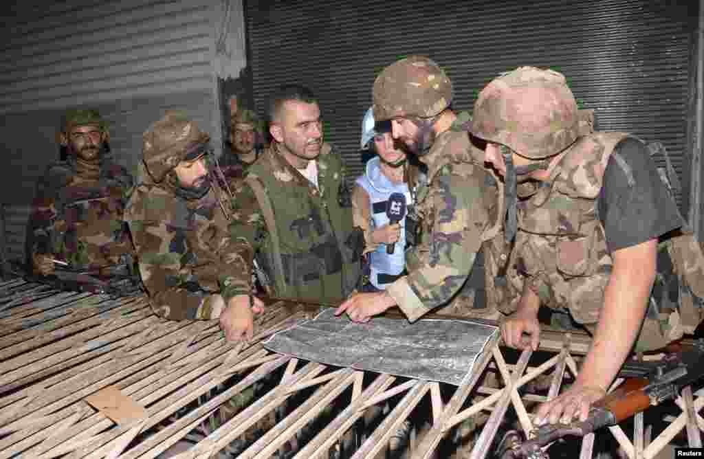 In this photo taken on guided government tour, Syrian army forces are seen at al-Sijen district, in the center of Aleppo, August 9, 2012.