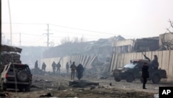 FILE - Afghan security forces gather at the site a day after an attack in Kabul, Afghanistan, Tuesday, Jan. 15, 2019.