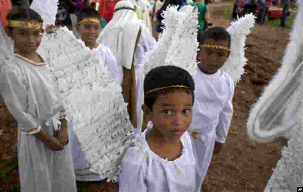 Children disguised as angels look at the camera before participating in a reenactment of the Passion of Christ on Good Friday during Holy Week celebrations in Arraijan, outskirts of Panama City, Friday April 6, 2012. Holy Week commemorates the last week o