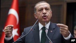 FILE - Turkish Prime Minister Recep Tayyip Erdogan addresses his supporters and lawmakers at the parliament in Ankara, Turkey.