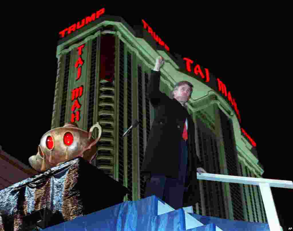 Donald Trump ascends the stairs with his fist raised from the genie's lamp after opening the Trump Taj Mahal Casino Resort in a spectacular show of fireworks and laser lights in Atlantic City, N.J., on April 5, 1990. Behind Trump is the 42-story hotel. 