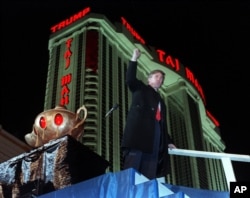 FILE - Donald Trump ascends the stairs with his fist raised from the genie's lamp after opening the Trump Taj Mahal Casino Resort in Atlantic City, N.J., April 5, 1990. Behind Trump is the 42-story hotel.