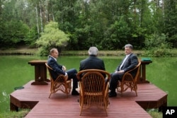 Ukrainian President, Petro Poroshenko, right, European Council President Donald Tusk, left, and European Commission President Jean-Claude Juncker talk during an informal meeting in Kyiv, Ukraine, July. 13, 2017.