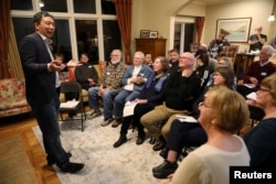 FILE - U.S. 2020 Democratic presidential candidate Andrew Yang speaks at Potluck Insurgency, a local Democratic activist event, at the home of one of its members in Iowa City, Iowa, March 10, 2019.