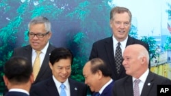 PM Vietnam Nguyen Xuan Phuc (kanan tengah) berjabat tangan dengan Menteri Perdagangan China Zhong Shan, (kiri tengah), saat Menteri Perdagangan Filipina Ramon Lopez (kiri atas), Perwakilan Dagang AS Robert Lighthizer (kanan atas) dan Menteri Perdagangan Peru Eduardo Ferreyros (bawah, kanan) seusai berfoto dalam pertemuan Menteri Perdagangan Asia Pasifik (APEC) di Hanoi, Vietnam, Sabtu, 20 Mei 2017. (AP Photo/Hau Dinh) 