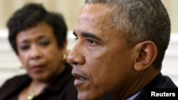 Le président Barack Obama, avec la procureure générale américaine Loretta Lynch qui la regarde, lors d'une réunion avec de hauts responsables américains sur les mesures pour le contrôle des armes, dans le Bureau ovale de la Maison Blanche à Washington, 4 janvier 2016.